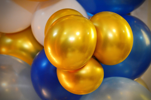Horizontal shot of bunch of silver golden white and blue colored shiny party balloons for happy cheerful celebrations backdrops, background, wallpaper