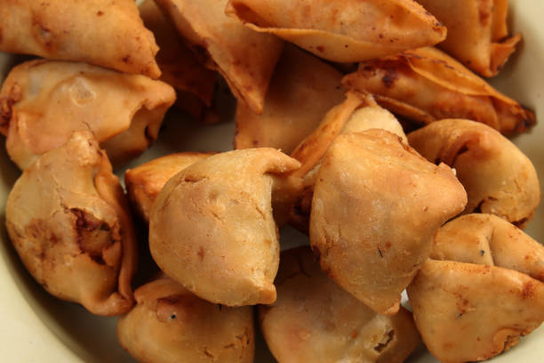 Deep fried samosa singara stuffed with potato minced meat vegetable benglai snacks on enamel tin metal plate
