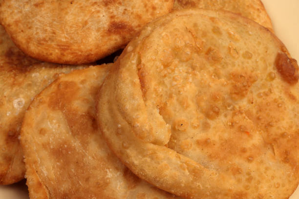 istock Deep fried stuffed pancakes aloo dal puri Bengali snacks on enamel tin metal plate 1986763647