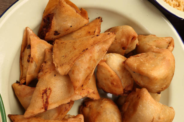 istock Deep fried samosa singara stuffed with potato minced meat vegetable benglai snacks on enamel tin metal plate 1986764191