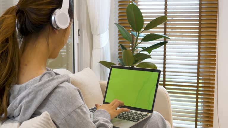 Empty Green Screen laptop Blogger Woman hands typing Laptop computer keyboard. Close up women hands using laptop sitting sofa living room. Freelance women work from home office video call conference