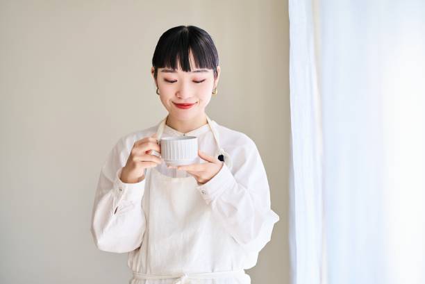 istock A young woman in an apron taking a break by the window 1986792572