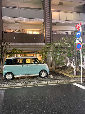 Tokyo, Japan - June 8, 2023: Japanese parking lot. Cars parked in the parking space or car port on streets of Tokyo City with building background.