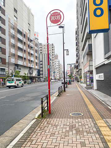 Tokyo, Japan - June 8, 2023: People are walking on pedestrian walk in Tokyo City during the day in summer with many buildings around.