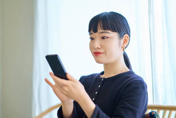 istock Young woman operating a smartphone 1986827788