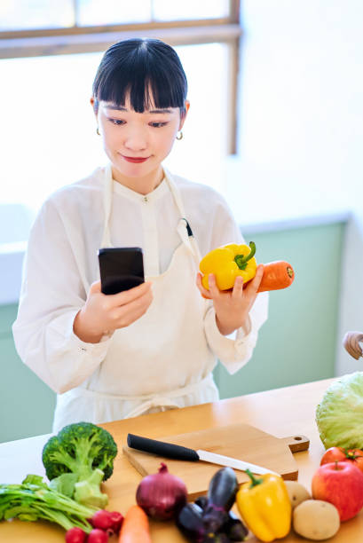 istock Young woman picking up vegetables and smartphone 1986834996