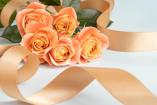 Image of love with orange roses and gold ribbon