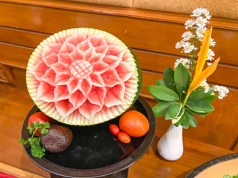 Carved watermelon for party decoration placed on a wooden table. The art of carving fruit