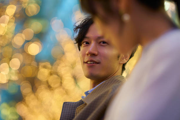 A man happily talking to a woman in an illuminated cityscape