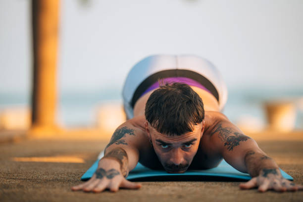 Young man doing yoga exercise Uttana shishosana or extended puppy pose