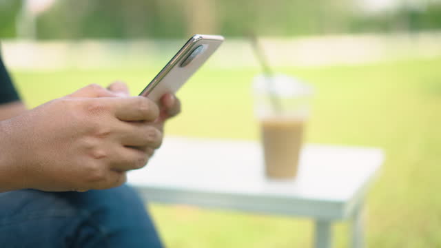 Man Using Phone While Relaxing In Cafe