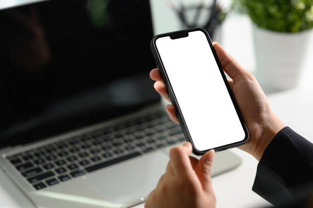istock Cropped shot businessman using mobile phone at office desk. Empty screen for your text message 1986921695
