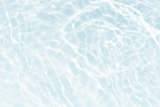 istock Water surface. Bluewater waves on the surface ripples blurred. Defocus blurred transparent blue colored clear calm water surface texture with splash and bubbles. Water waves with shining pattern. 1986927021