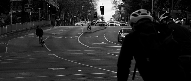 Melbourne, Australia – March 15, 2022: A grayscale of pedestrians and cyclists crossing a city street