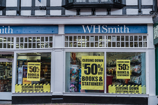 Nantwich, Cheshire, England, February 4th 2024. WHSmith store with closing down sale signs in the windows, offering up to 50% off on books and stationery.