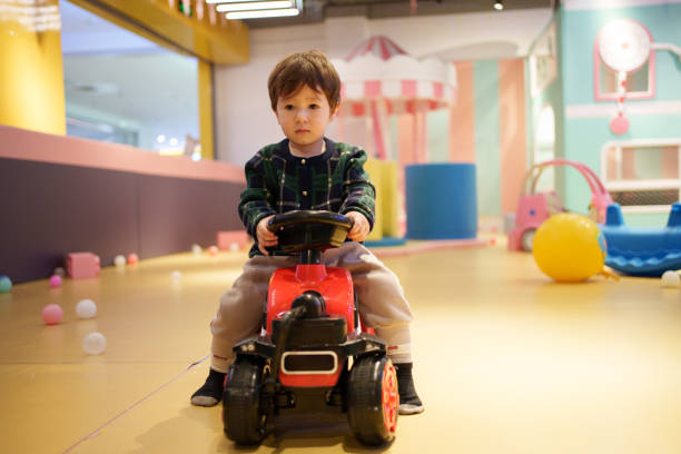 Mixed race child driving toy car