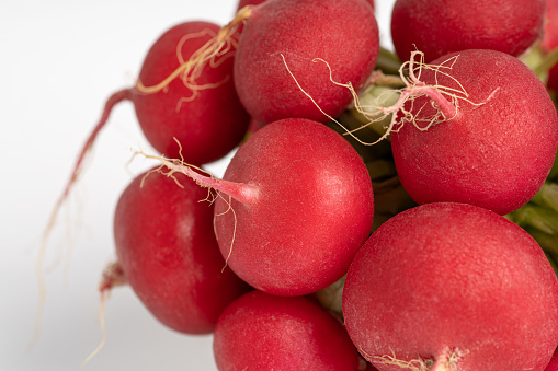 A bundle of fresh radish on a white background. Vegetarian and diet concept