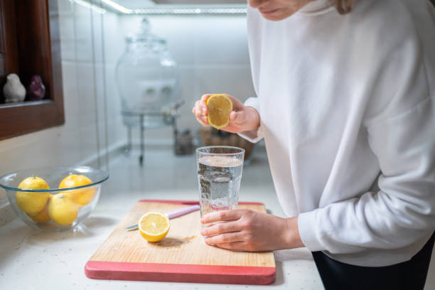 istock Woman Squeezing Out Juice Of Lemon 1987007551