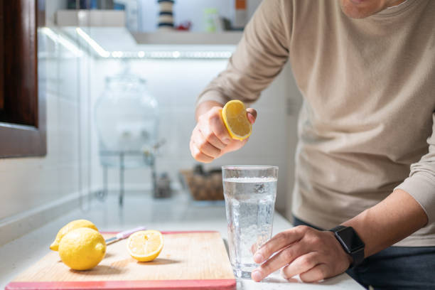 istock Woman Squeezing Out Juice Of Lemon 1987009137