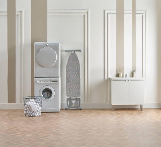 istock Washing dryer machine and ironing table interior style, laundry room, white and brown vertical wall background. 1987028957