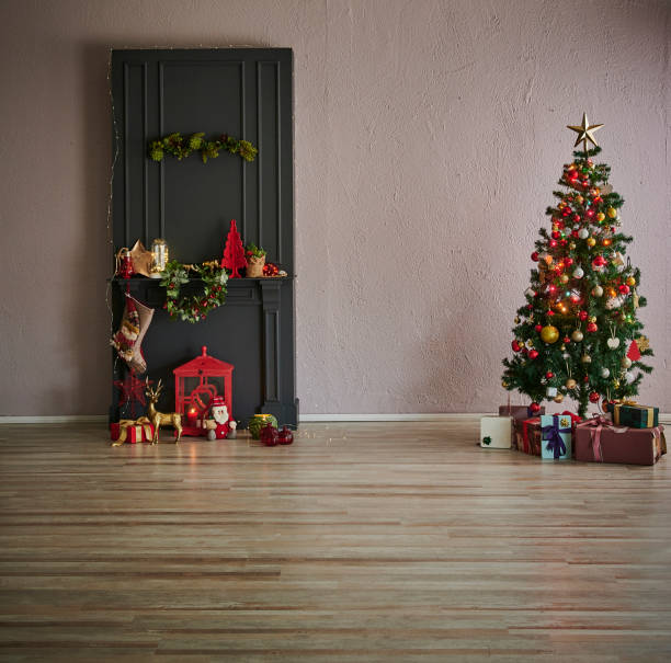 istock Black fireplace, tree ornament gift box accessory and happy new year concept interior. 1987034718