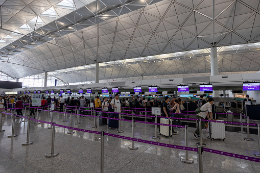 Hong Kong - April 17, 2023 : Travelers at the HK Express check-in counters at departure hall of the Hong Kong International Airport in Hong Kong.