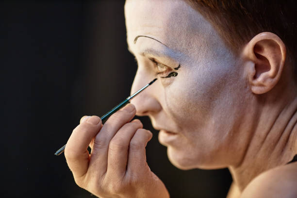 istock Artist Doing Mime Makeup by Mirror 1987065336