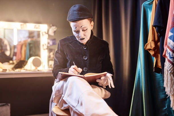 istock Mime Preparing For Show Backstage and Writing in Notebook 1987065876
