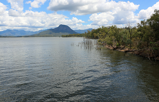 Mount Greville from Moogerah Dam. Across the deep, rippling water, under semi-overcast sky.