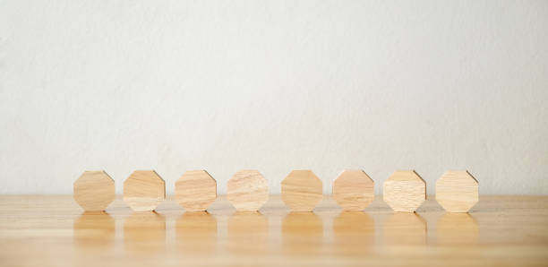 istock 8 blank octagon wood blocks on table over white background, copy space for text 1987066956