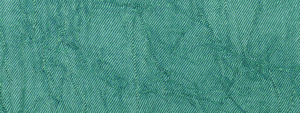 istock Dark green and cyan wavy background from textile material. Texture of emerald fabric, macro. 1987078121