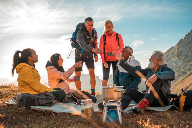 istock Refreshing Tea Break on Hilltop with Diverse Group Trekking with Backpacks 1987087420