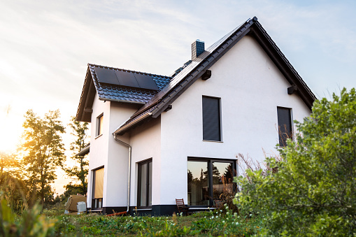 Exterior of a newly built single-family home in Germany. The house has solar panels on the roof and is built to modern standards in terms of sustainability.