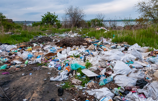 ODESSA region, UKRAINE - APRIL 30, 2017: Heaps of plastic trash on the shore of the reservoir. Ecology of nature, unorganized garbage dump