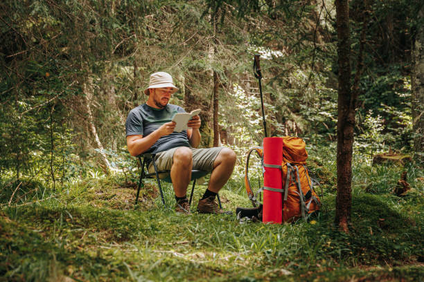 istock Trailside Tranquility Young Hiker Immersed in a Captivating Book 1987094214