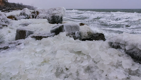 Frozen Black Sea, ice-covered and frozen coastal rocks in the piers, harsh winter