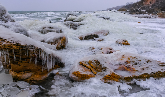 Frozen Black Sea, ice-covered and frozen coastal rocks in the piers, harsh winter