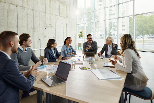 Large group of happy business colleagues communicating while working on a meeting in the office. Copy space.