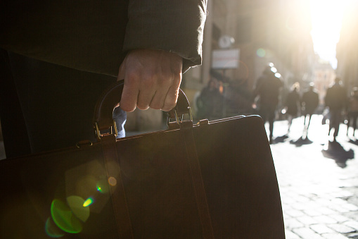 Businessman holding a suitcase in the city