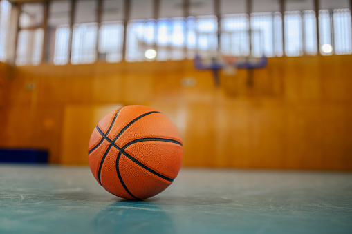 A basketball on basketball court with no people around. Concept of training, teamwork, team spirit and competition. A ball on basketball court, sports equipment only without people. Copy space.