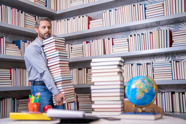 istock university teacher professor in school classroom library preparing for exam reading books getting knowledge and education at teachers day 1987107645