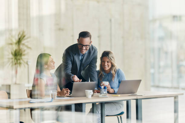 istock Happy business team working on laptop in the office. 1987108159