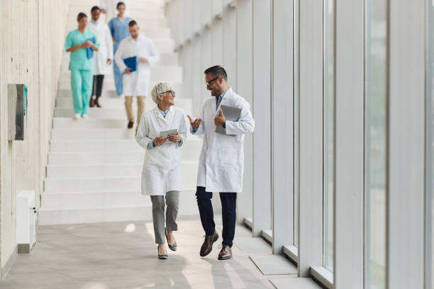 istock Happy doctors talking while walking through hallway of a hospital. 1987112386