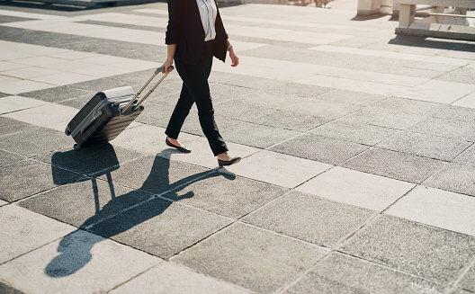 Business person, professional or travel with suitcase for company, walk or employee commute in city outdoor. Lawyer, luggage or journey of corporate traveller to international work convention in town