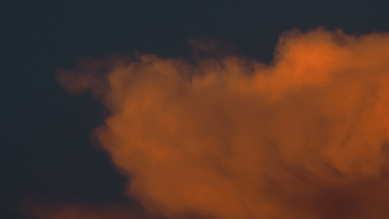 Vue rapprochée de cumulus bourgeonnants aux teintes orangées, pendant le crépuscule