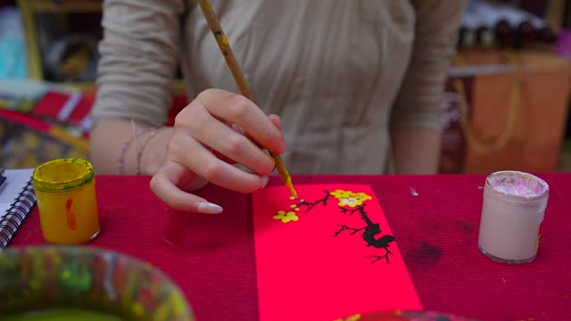 Selective focus of hand of Vietnamese scholar writes calligraphy at lunar new year. Calligraphy festival is a popular tradition during Tet holiday.