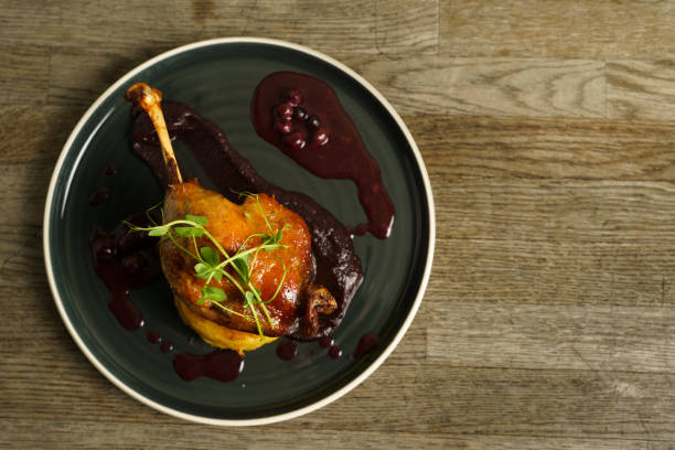 Roasted duck leg on mashed potatoes with onion, purple cabbage cream and blueberry jus