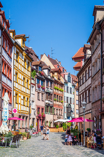 Nuremberg, Germany - August 23, 2023: The Weißgerbergasse is a pedestrian street in the old town, famous for the preserved medieval half-timbered townhouses, lined with sidewalk cafes and galleries.