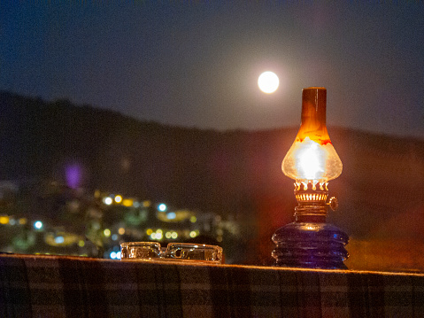 Oil lamp on the table and full moon in Bodrum, Turkey