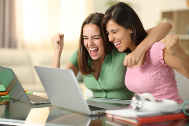 istock Excited students celebrating online news 1987154472